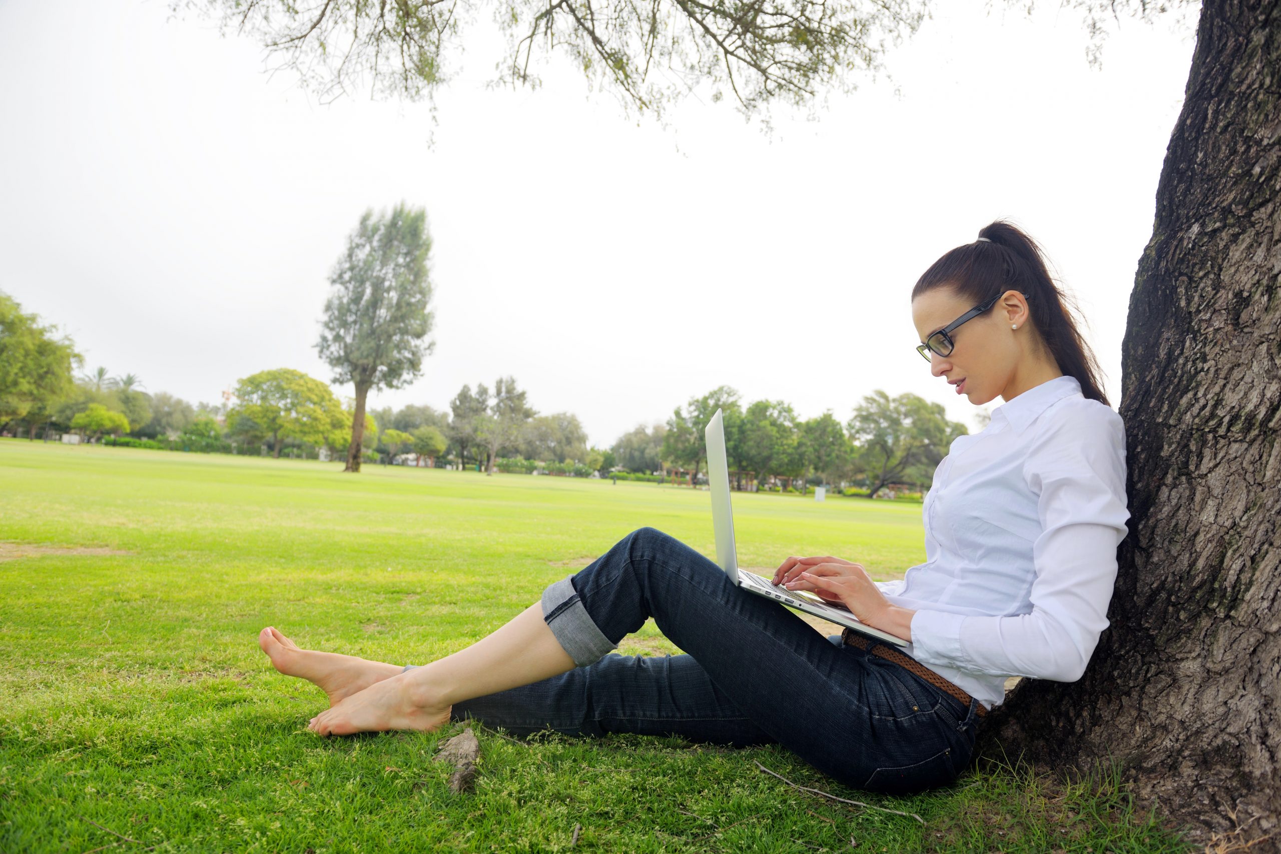 woman with laptop in park